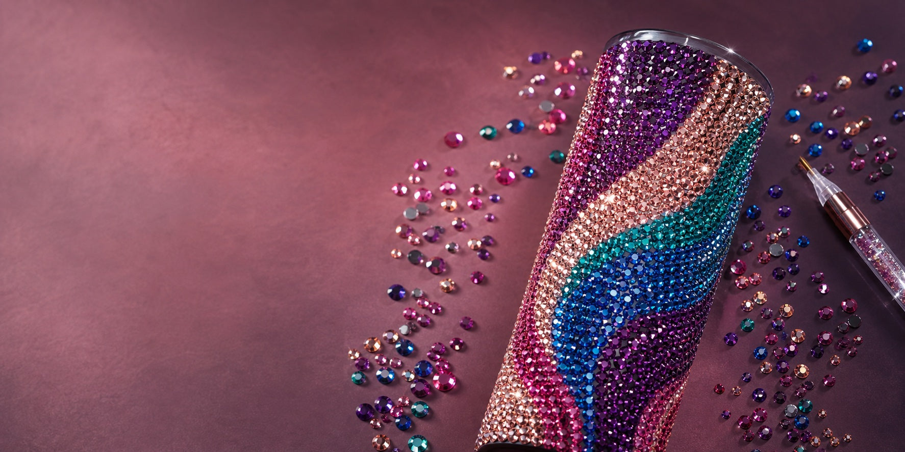A 20oz straight tumbler fully covered in colourful round rhinestones with loose stones and a precision tool