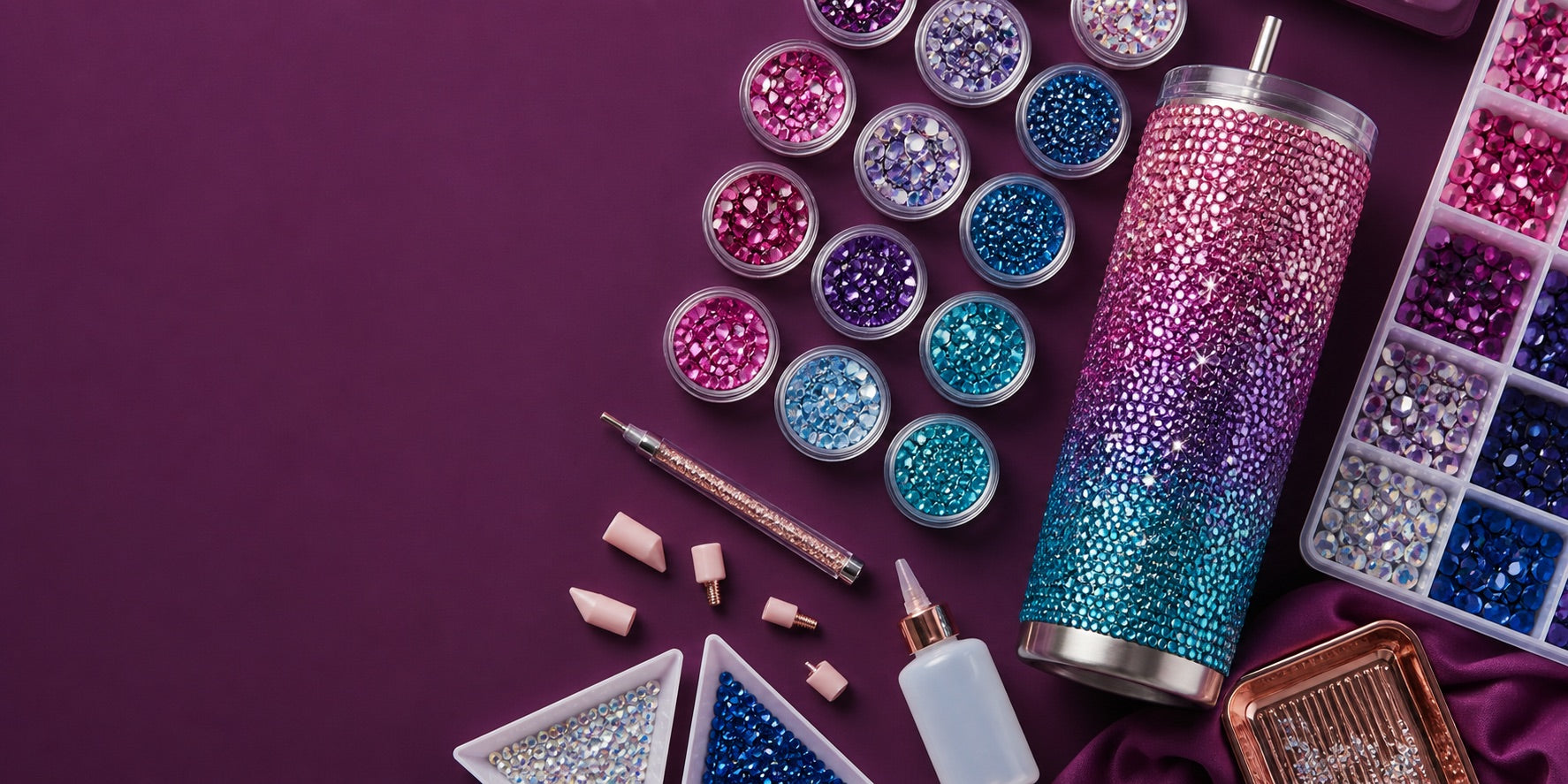 An organized rhinestone starter kit with round stones, pickup tools, trays and a 20oz tumbler project